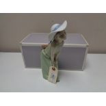 A Lladro figure - Curious girl wistraw hat, boxed.