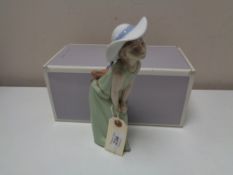 A Lladro figure - Curious girl wistraw hat, boxed.