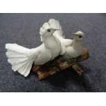 A Capo De Monte figure of a pair of doves on naturalistic plinth