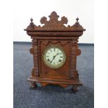 An Edwardian oak mantel clock with enamel dial by the Ansonia clock company