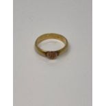 An antique yellow metal band ring with heart motif, size O, 4.2g.