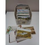 A box of early twentieth century and later colour and black and white postcards