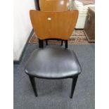 A set of eight mid century plywood and vinyl seated dining chairs