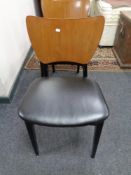 A set of eight mid century plywood and vinyl seated dining chairs