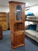 A pine glazed corner cabinet