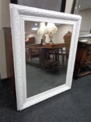 A contemporary white framed mirror