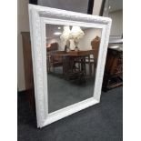 A contemporary white framed mirror