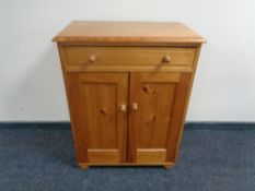 A pine double door cabinet together with a wicker framed mirror