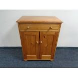 A pine double door cabinet together with a wicker framed mirror