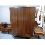 A mid century four piece bedroom suite comprising of triple door wardrobe, bedside cabinet,