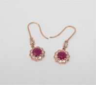 A pair of 14ct rose gold ruby and diamond earrings, the rubies weighing 2.