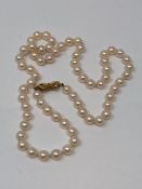 A cultured pearl necklace on 9ct bow clasp, each pearl diameter approximately 6.2 mm, length 50 cm.