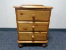 A pine three drawer bedside chest