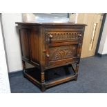 A carved oak side cabinet with a drawer and cabinet door