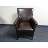 A stitched brown leather armchair