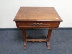 A reproduction mahogany work table with under stretcher and column supports