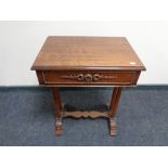 A reproduction mahogany work table with under stretcher and column supports