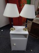 A modern white bedside cabinet and pair of lamps