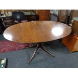 An oval inlaid mahogany pedestal dining table