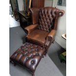 A brown leather Chesterfield style armchair with matching footstool CONDITION REPORT: