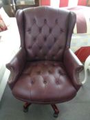 A Burgundy studded vinyl office swivel chair