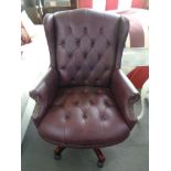 A Burgundy studded vinyl office swivel chair