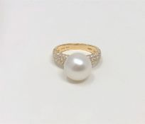 A 14ct yellow gold pearl and diamond ring featuring a cultured Akoya pearl with fifty six round