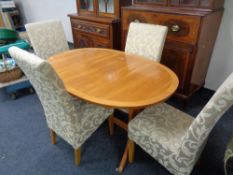 A Nathan teak extending dining able with four two-tone upholstered chairs