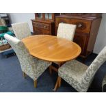 A Nathan teak extending dining able with four two-tone upholstered chairs