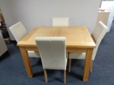 A contemporary light oak extending dining table with four cream leather chairs CONDITION