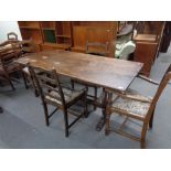 An oak refectory dining table together with six ladder backed chairs