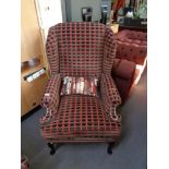 An antique style armchair upholstered in symmetrical fabric