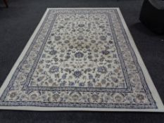 A contemporary machine made carpet on cream ground with floral borders