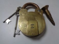 A large 19th century brass padlock with two keys and a screw CONDITION REPORT: This