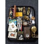 A tray of collectables inclduing pens, nut crackers, miniature brass toilet cistern,
