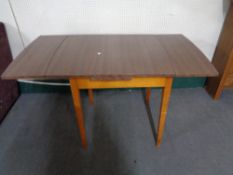 A mid century dining table together with three chairs