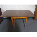 A mid century dining table together with three chairs