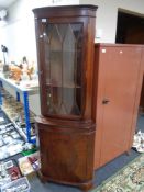 A reproduction mahogany corner cabinet