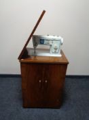 A twentieth century walnut sewing cabinet with Singer sewing machine and accessories