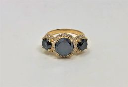 A 14ct gold black diamond trilogy ring, the black diamonds weighing 3.35 carats, further set with 0.