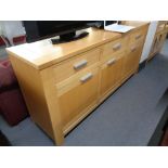 A beech sideboard fitted with three drawers