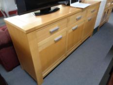 A beech sideboard fitted with three drawers