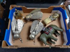 Three metal fly ornaments together with a cast elephant figure,