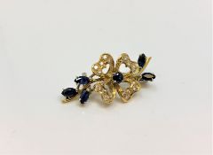 An 18ct gold diamond and sapphire brooch, 7.2g, width 38 mm.