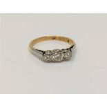 An 18ct gold three stone diamond ring, size M CONDITION REPORT: 2.