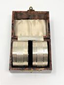 A pair of boxed silver napkin rings with engine turned decoration,