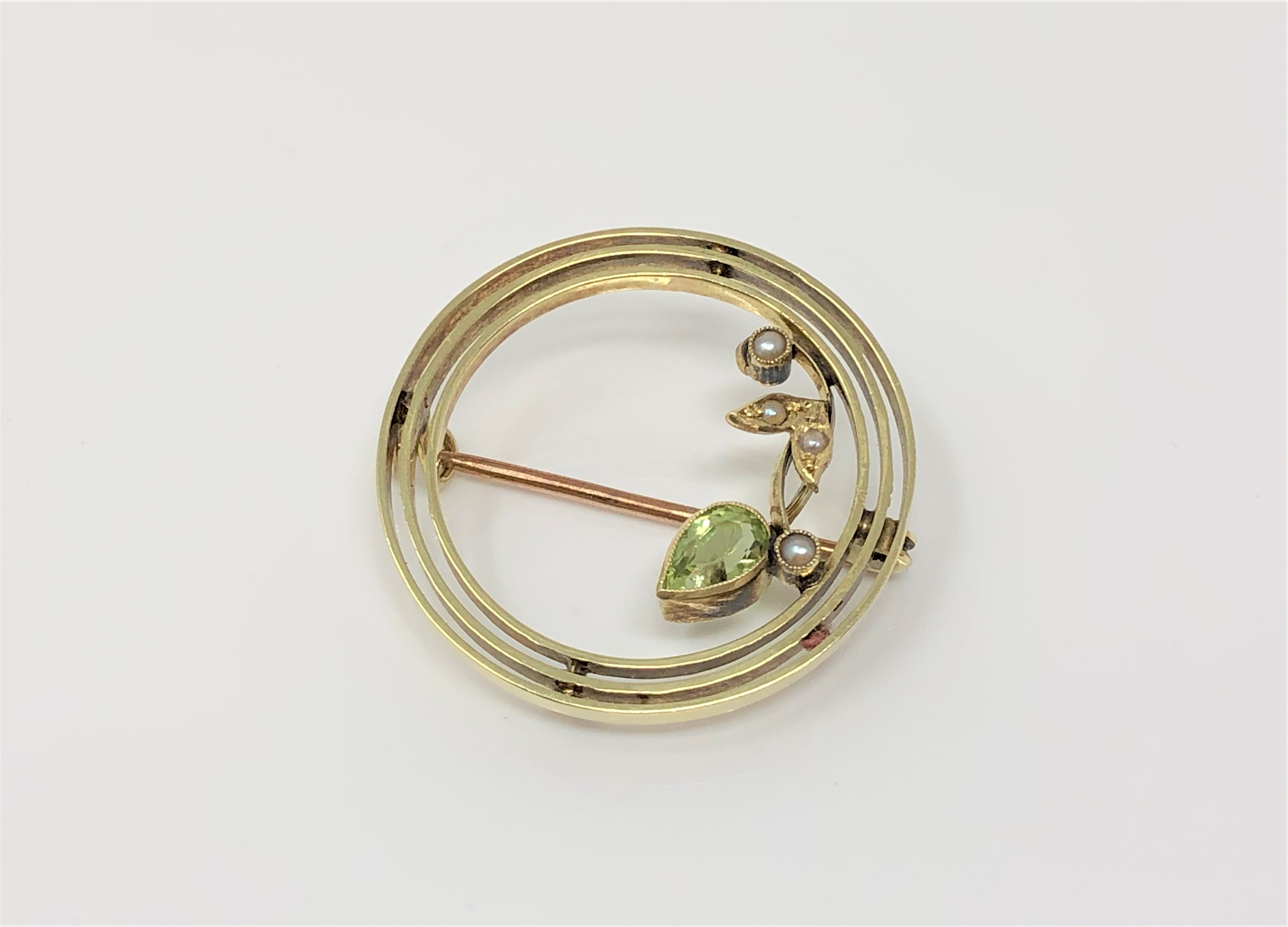 An Edwardian 15ct gold peridot and seed pearl brooch CONDITION REPORT: 3.