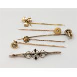 A group of gold stick pins and a brooch including one diamond set example CONDITION