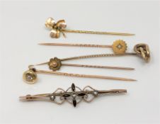 A group of gold stick pins and a brooch including one diamond set example CONDITION