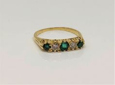 An 18ct gold five stone emerald and diamond ring, size P CONDITION REPORT: 3.